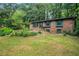 Charming brick home features a well-manicured lawn, landscaping, and an attached garage at 1094 Seville Dr, Clarkston, GA 30021