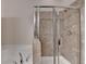 Detail of a modern bathroom showing a luxurious soaking tub, glass shower and neutral tile surround at 3123 Cross Creek Dr, Cumming, GA 30040