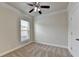 A bright carpeted bedroom featuring a ceiling fan, a window, and a closet at 3123 Cross Creek Dr, Cumming, GA 30040