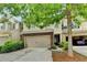 Inviting townhome with a two-car garage, brick facade, and well-maintained landscaping at 3123 Cross Creek Dr, Cumming, GA 30040