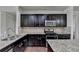 A kitchen with dark cabinetry, granite countertops, stainless steel appliances, and hardwood floors at 3123 Cross Creek Dr, Cumming, GA 30040