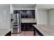 A kitchen featuring dark cabinets, granite countertops, stainless steel appliances, and hardwood floors at 3123 Cross Creek Dr, Cumming, GA 30040