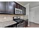 A kitchen with dark cabinets, granite countertops, stainless steel appliances, and tile backsplash at 3123 Cross Creek Dr, Cumming, GA 30040