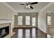 Spacious living room features a brick fireplace, hardwood floors, three windows, and a ceiling fan at 3123 Cross Creek Dr, Cumming, GA 30040