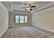 A large carpeted main bedroom featuring a trey ceiling and large window that provides natural light at 3123 Cross Creek Dr, Cumming, GA 30040