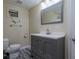 Bathroom featuring a vanity with gray cabinets, toilet, and window AC, providing essential amenities and comfort at 152 Stoneforest Dr, Woodstock, GA 30189