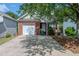 Charming brick home with a one-car garage and driveway, complemented by mature landscaping at 152 Stoneforest Dr, Woodstock, GA 30189