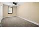 This bedroom has carpeted floors, a ceiling fan, and a window at 256 Grist Mill Ln, Lawrenceville, GA 30046