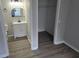 Bathroom and walk-in closet featuring wood grain vinyl flooring, a modern vanity, mirror and bright lighting at 3201 Fairington Dr, Lithonia, GA 30038