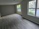 Spacious living room with gray walls and wood flooring, complemented by natural light from large windows at 3201 Fairington Dr, Lithonia, GA 30038