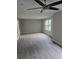 An airy living room featuring a ceiling fan, natural light and wood grain vinyl flooring at 3201 Fairington Dr, Lithonia, GA 30038