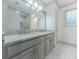 Bright bathroom features dual sinks with granite countertops, undermount sinks, and a large mirror at 1265 Watercrest Cir, Lawrenceville, GA 30043