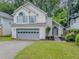 Charming two-story home featuring a gray garage door, a well-manicured lawn, and fresh landscaping at 1265 Watercrest Cir, Lawrenceville, GA 30043