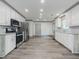 Open kitchen showcasing stainless steel appliances, granite counters and new wood floors at 1265 Watercrest Cir, Lawrenceville, GA 30043