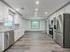 Modern kitchen featuring stainless steel appliances, white cabinets, and gray wood-look floors at 1265 Watercrest Cir, Lawrenceville, GA 30043