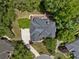 Aerial view of the home featuring a dark roof, deck, driveway, and mature trees at 330 Broad Leaf Ct, Johns Creek, GA 30022
