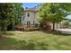 Home exterior with deck, lush lawn, mature trees, and a brick-lined landscape border at 330 Broad Leaf Ct, Johns Creek, GA 30022