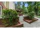 Backyard with brick planter beds, white gate, walkway to deck, and lush greenery at 330 Broad Leaf Ct, Johns Creek, GA 30022