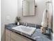 Bathroom featuring a white vanity, marble countertop, decorative mirror, and modern fixtures for a refined and functional space at 330 Broad Leaf Ct, Johns Creek, GA 30022