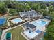 Aerial view of community pools with multiple swimming areas and lounge chairs surrounding a grand clubhouse at 330 Broad Leaf Ct, Johns Creek, GA 30022