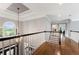Elegant hallway boasts hardwood floors, a modern chandelier, and a staircase that leads to the entryway at 330 Broad Leaf Ct, Johns Creek, GA 30022