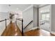 Hallway with hardwood floors, white railings, and view into bedroom with natural light at 330 Broad Leaf Ct, Johns Creek, GA 30022