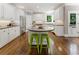 Bright kitchen featuring white cabinets, stainless appliances, kitchen island with bar stool seating and hardwood floors at 330 Broad Leaf Ct, Johns Creek, GA 30022