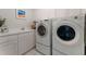 Bright laundry room with front loading washer and dryer, white cabinets, countertop and sink at 330 Broad Leaf Ct, Johns Creek, GA 30022