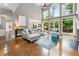 Sun-filled living room boasting tall ceilings, a fireplace, hardwood floors, and backyard views at 330 Broad Leaf Ct, Johns Creek, GA 30022