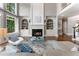 Bright living room with fireplace, built-ins, hardwood floors and large windows showcasing wooded outdoors at 330 Broad Leaf Ct, Johns Creek, GA 30022