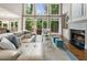 Comfortable living room featuring fireplace, plush seating, and views of the private outdoor greenery at 330 Broad Leaf Ct, Johns Creek, GA 30022
