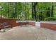 Outdoor patio with wrought iron furniture, brick accents, and a tranquil wooded backdrop at 330 Broad Leaf Ct, Johns Creek, GA 30022