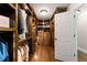 Spacious walk-in closet with custom wood shelving, multiple hanging rods, drawers and shoe racks at 330 Broad Leaf Ct, Johns Creek, GA 30022