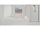 All-white bathroom features jacuzzi tub and separate shower with glass door at 604 Bassett Se Ct, Smyrna, GA 30080