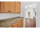 Light wood Butlers Pantry with granite countertop, and doorway to a brightly lit living area at 604 Bassett Se Ct, Smyrna, GA 30080