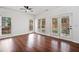 Bright living room featuring hardwood floors, ceiling fan and multiple windows for natural light at 604 Bassett Se Ct, Smyrna, GA 30080