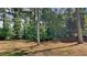 The cleared backyard homes mature trees on a lush lot at 6845 Gledhill Way, Stone Mountain, GA 30087