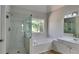 Bright bathroom features a glass shower, soaking tub, and white vanity at 6845 Gledhill Way, Stone Mountain, GA 30087