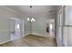 Bright dining room featuring hardwood floors, chair rail, and stylish lighting fixture at 6845 Gledhill Way, Stone Mountain, GA 30087