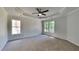 Main bedroom featuring tray ceiling, ceiling fan, neutral carpet, and lots of sunlight at 6845 Gledhill Way, Stone Mountain, GA 30087
