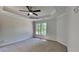 Spacious main bedroom with neutral carpet, tray ceiling and ceiling fan at 6845 Gledhill Way, Stone Mountain, GA 30087