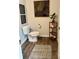 Powder room features toilet, wooden decorative shelves, black and gold wall art, and a patterned rug at 1195 Park Center Cir, Austell, GA 30168