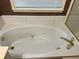 Close-up of bathtub with jacuzzi jets and gold fixtures at 3222 Wyndham Park Ct, Decatur, GA 30034