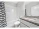 Well-lit bathroom with granite countertop, tub with tile surround, and modern fixtures at 3760 Oxford Cir, Doraville, GA 30340