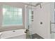 Stylish bathroom featuring a glass shower door, soaking tub, and pebble tile flooring at 4311 Sentinel Nw Pl, Kennesaw, GA 30144