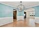 Chic dining room featuring blue walls, wainscoting, and modern chandelier at 4311 Sentinel Nw Pl, Kennesaw, GA 30144