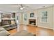 Inviting living room featuring a brick fireplace, hardwood floors, and an open layout to the kitchen at 4311 Sentinel Nw Pl, Kennesaw, GA 30144