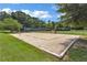 Outdoor sand volleyball court surrounded by green grass and mature trees at 4311 Sentinel Nw Pl, Kennesaw, GA 30144