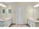 Bright bathroom featuring double vanities, neutral tiling, and a central door at 4330 Volnay Ne Ct, Marietta, GA 30066