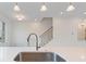 Kitchen island with stainless steel sink and faucet fixtures, and open concept design with staircase at 1309 Bennett Creek Ovlk, Suwanee, GA 30024